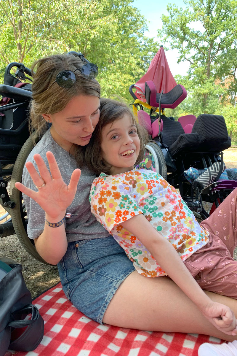 Eine Frau und ein junges Mädchen sitzen auf einer Picknickdecke