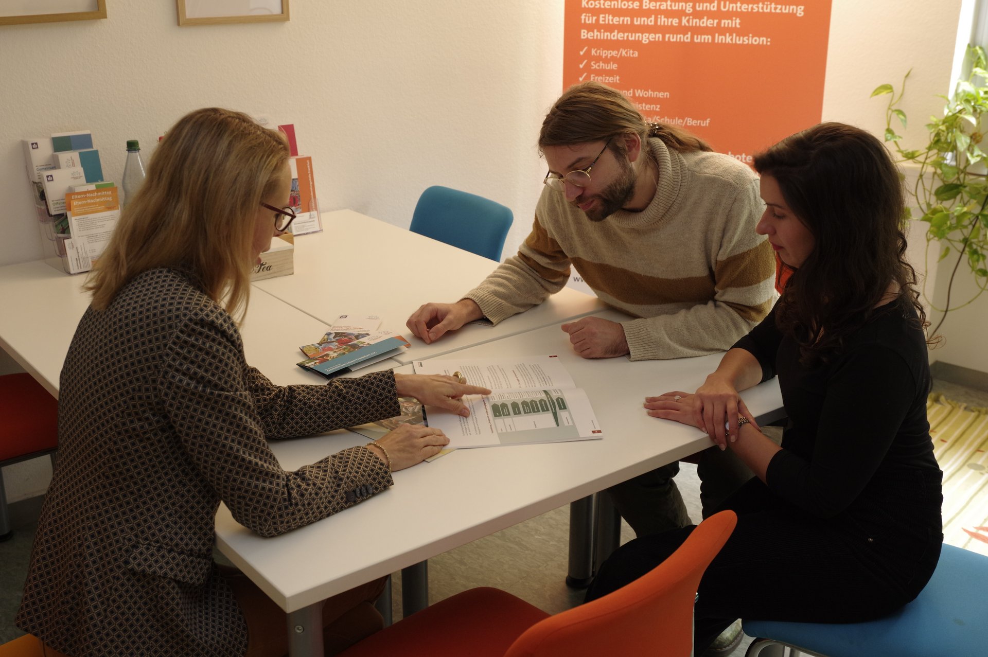 Eine Beratungssituation mit drei Personen im Beratungsraum